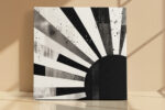 Bold monochrome rising sun with radiating rays and ink splatter, contemporary mixed-media abstract canvas for living room